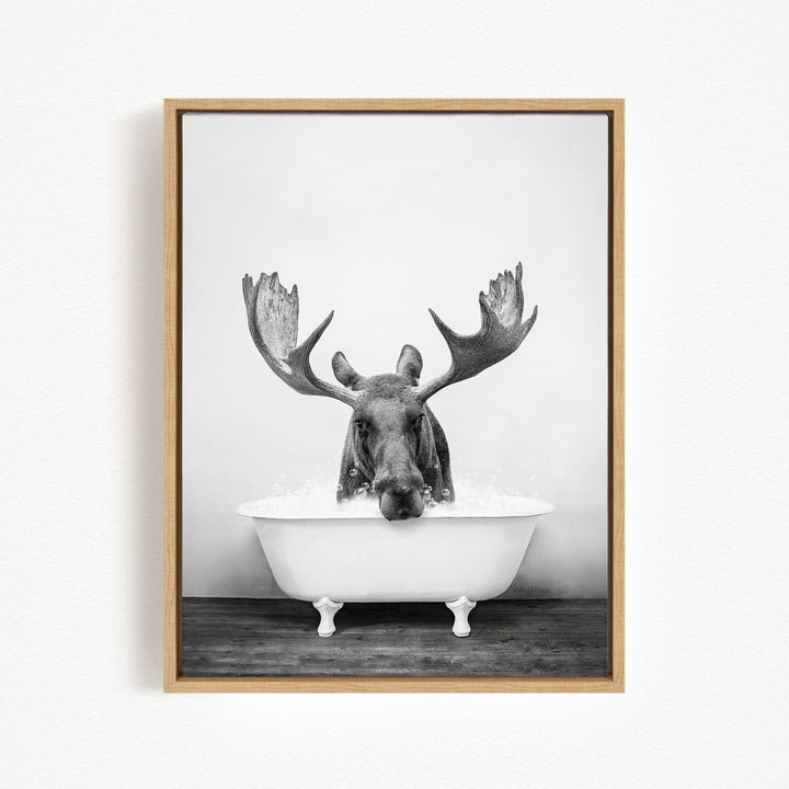 A moose with large antlers is sitting in a bathtub filled with water, creating a whimsical and humorous scene.