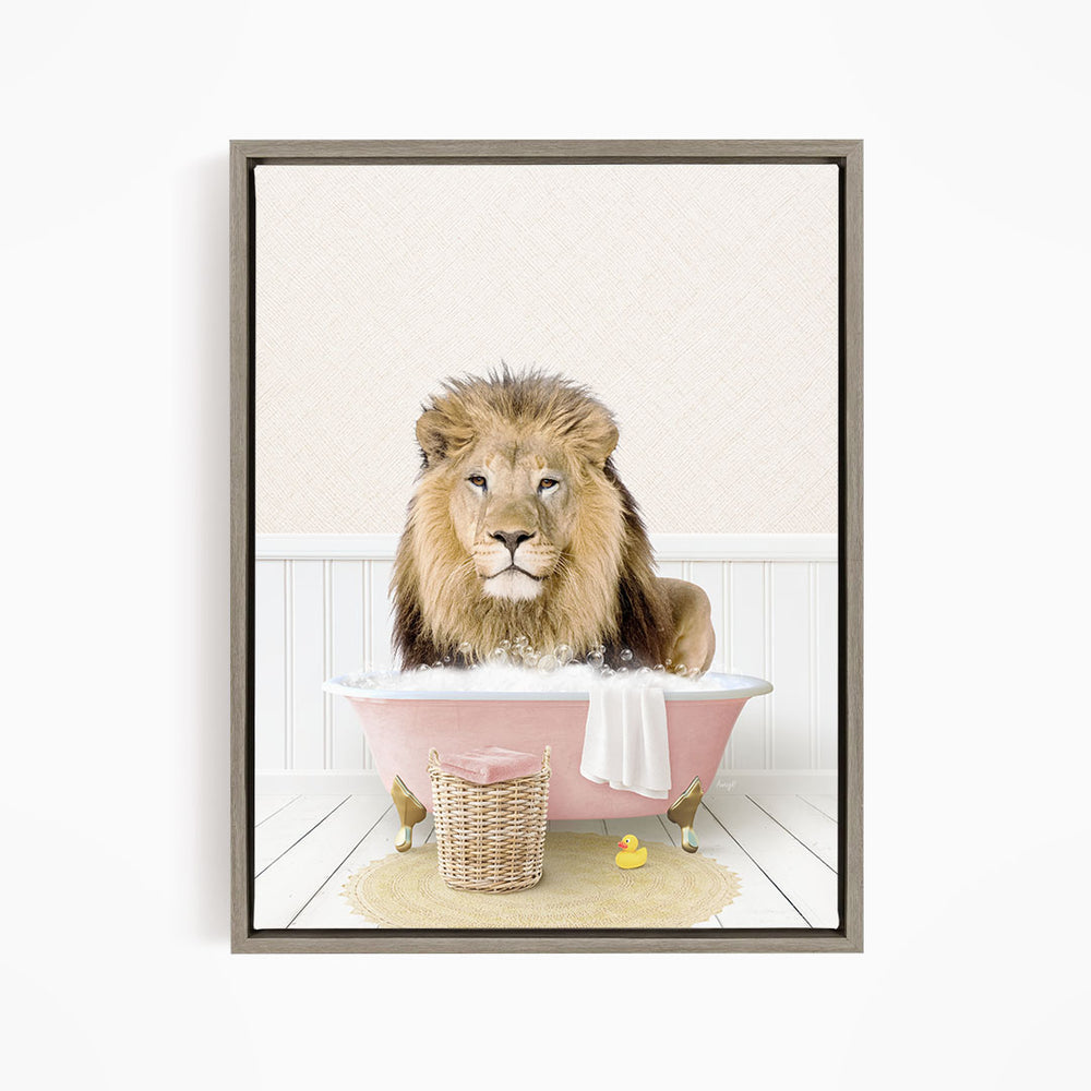 A lion sitting in a pink bathtub filled with water, surrounded by a basket of toys and a yellow rubber ducky.