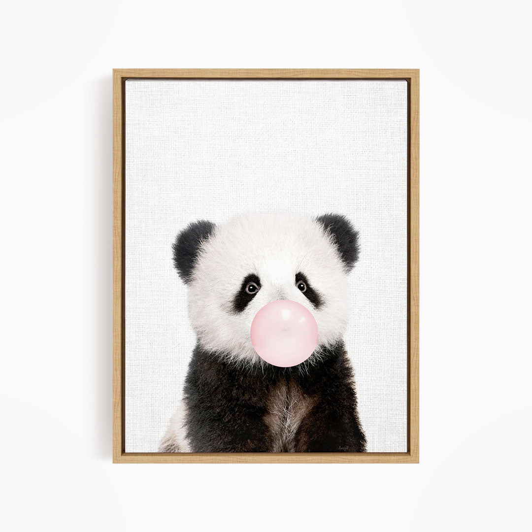 A panda bear blowing a bubble with a pink bubble gum bubble.