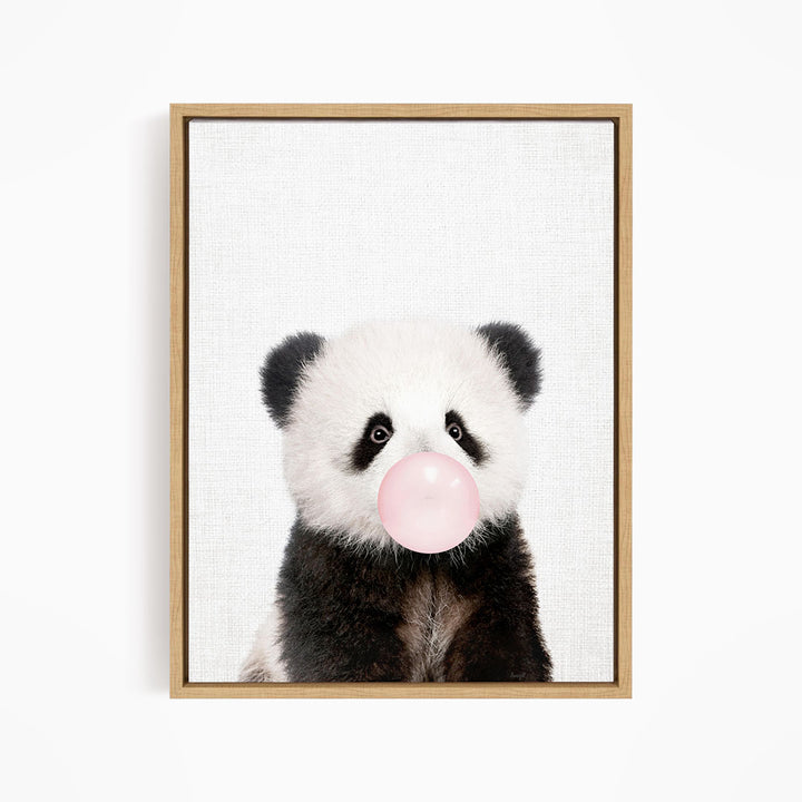 A panda bear blowing a bubble with a pink bubble gum bubble.