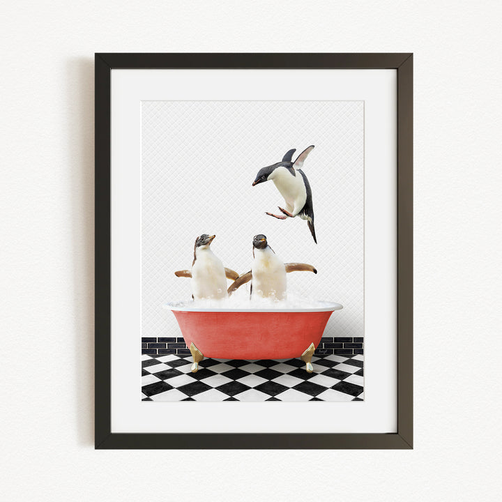 A framed image depicting two penguins sitting in a red bathtub, with one penguin flying towards the other in mid-air.