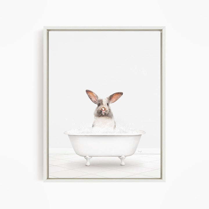 A white rabbit sitting in a white bathtub filled with water, looking directly at the camera.