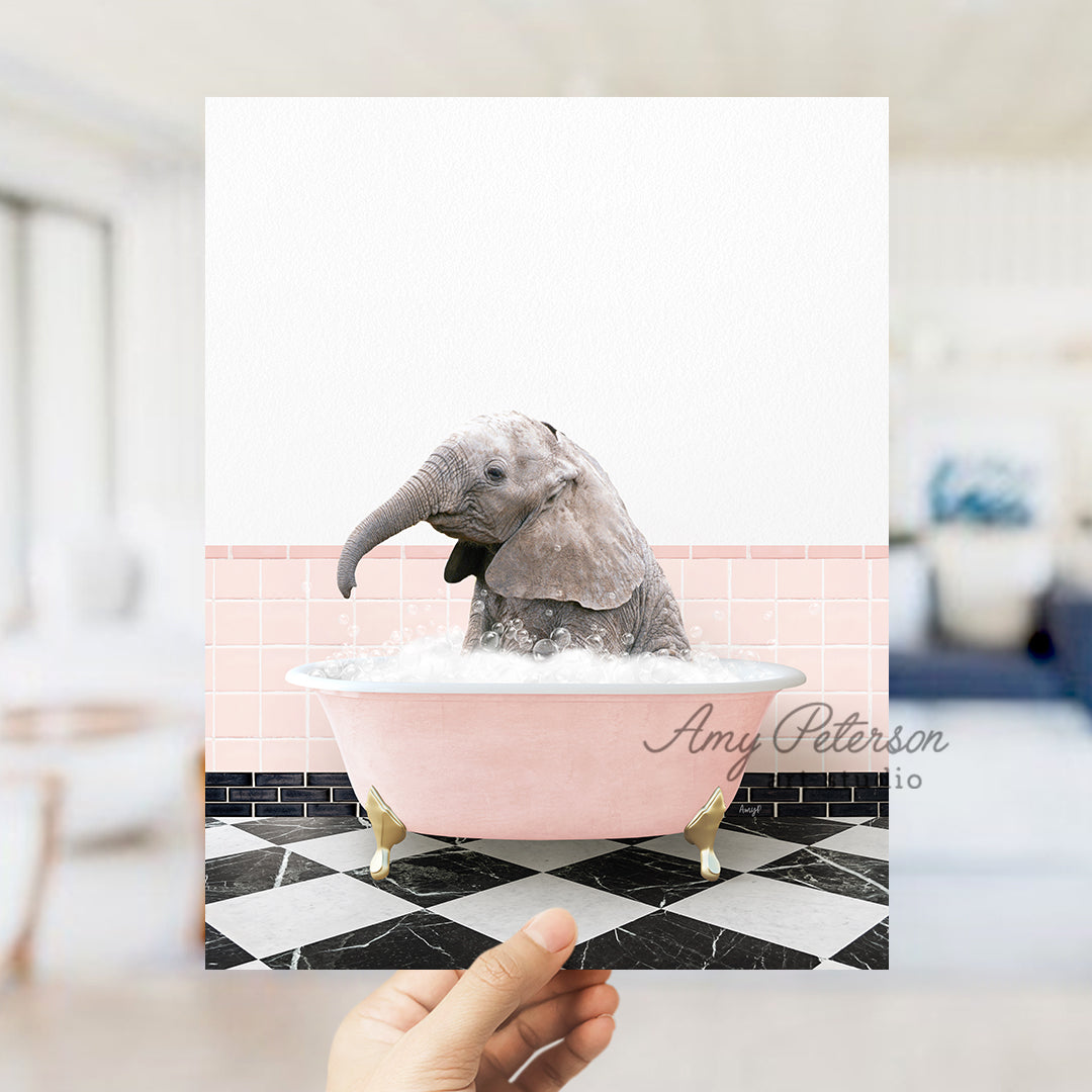 a person holding up a card with a picture of a baby elephant in a bath