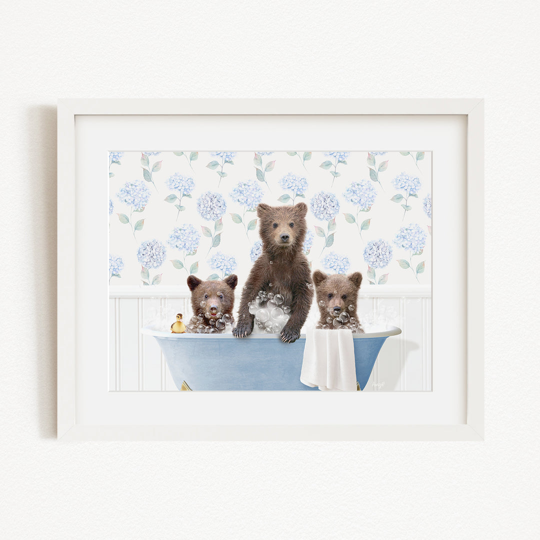 A framed image depicting three bears sitting in a bathtub, with one bear standing and the other two sitting.