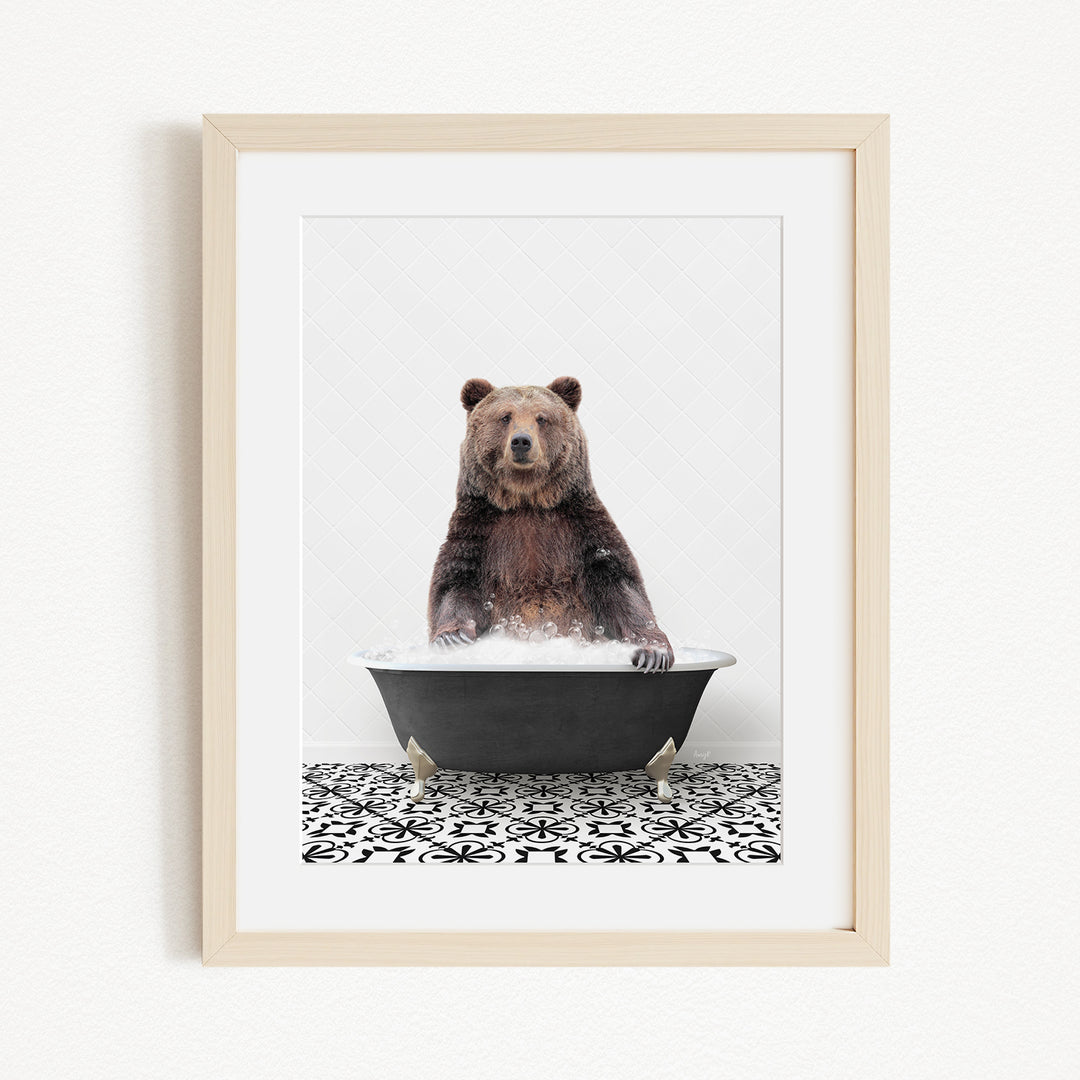 A brown bear sitting in a black bathtub filled with water, surrounded by a black and white patterned floor.