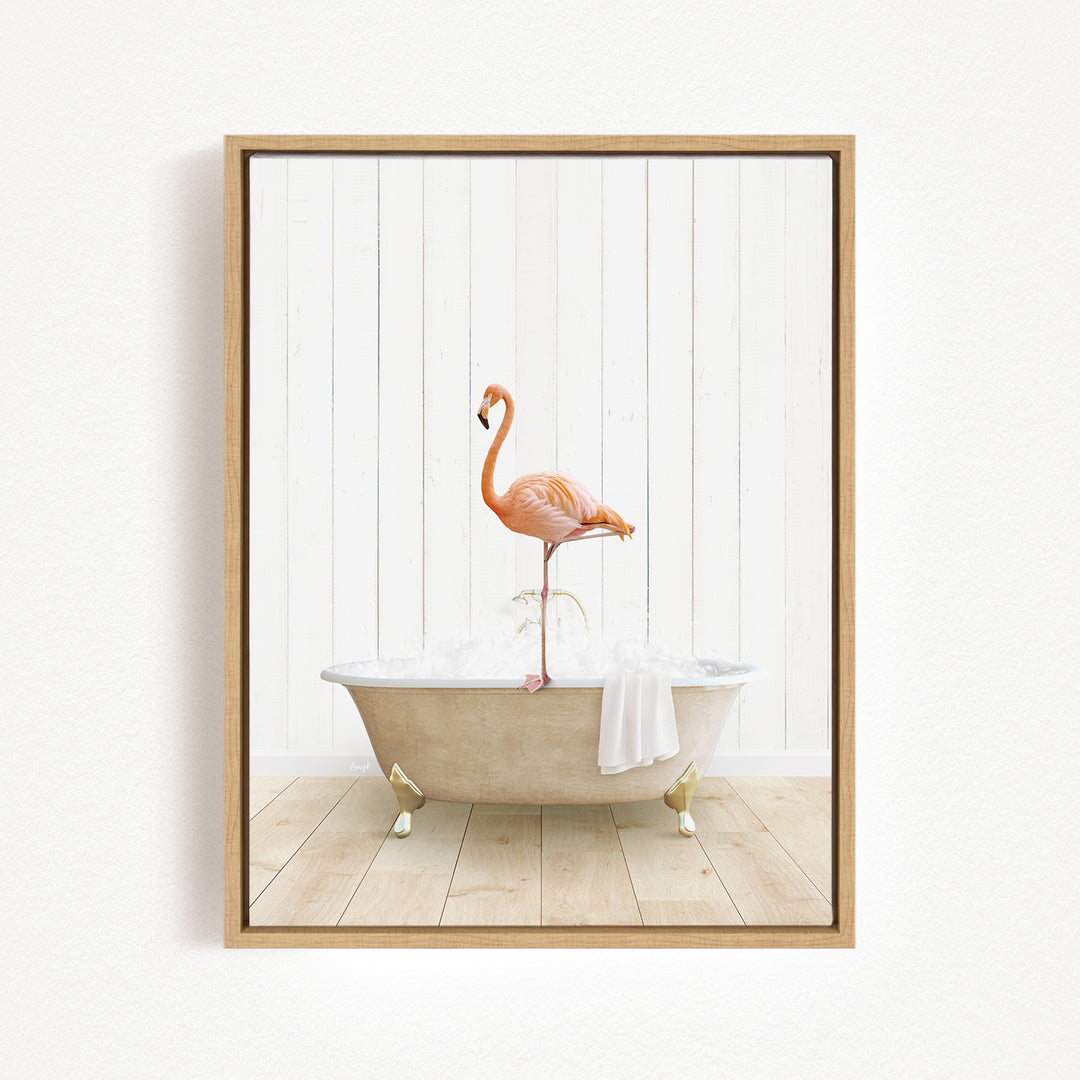 A framed image depicting a pink flamingo standing on a white bathtub filled with water, with a towel hanging on the side.