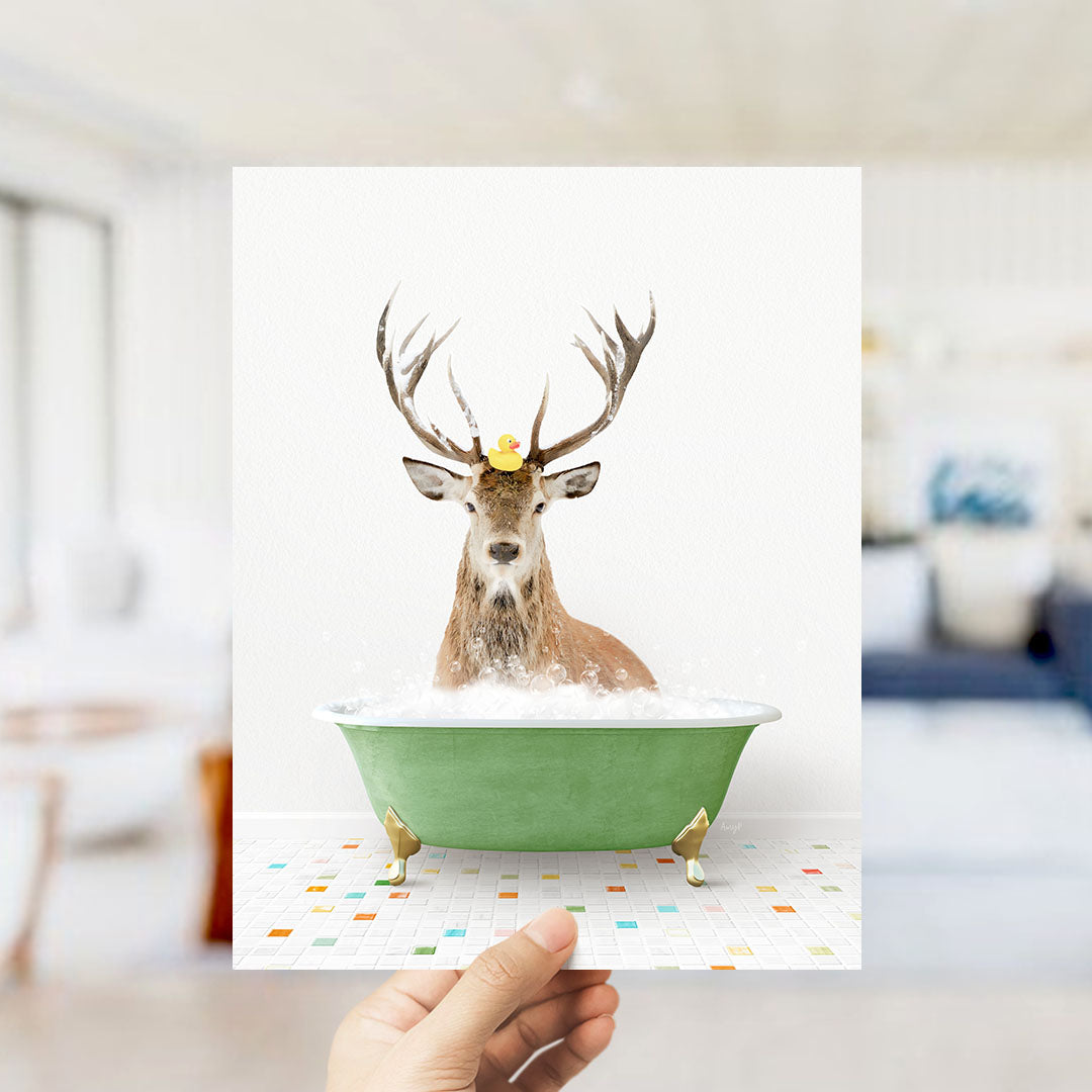 A deer with antlers is sitting in a green bathtub filled with bubbles, with a rubber duck floating on its head.