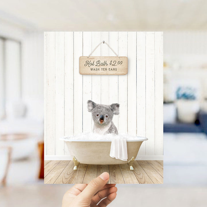 A koala sitting in a bathtub, with a sign above it that says "Hot Bath $2.00 WASH EARS".