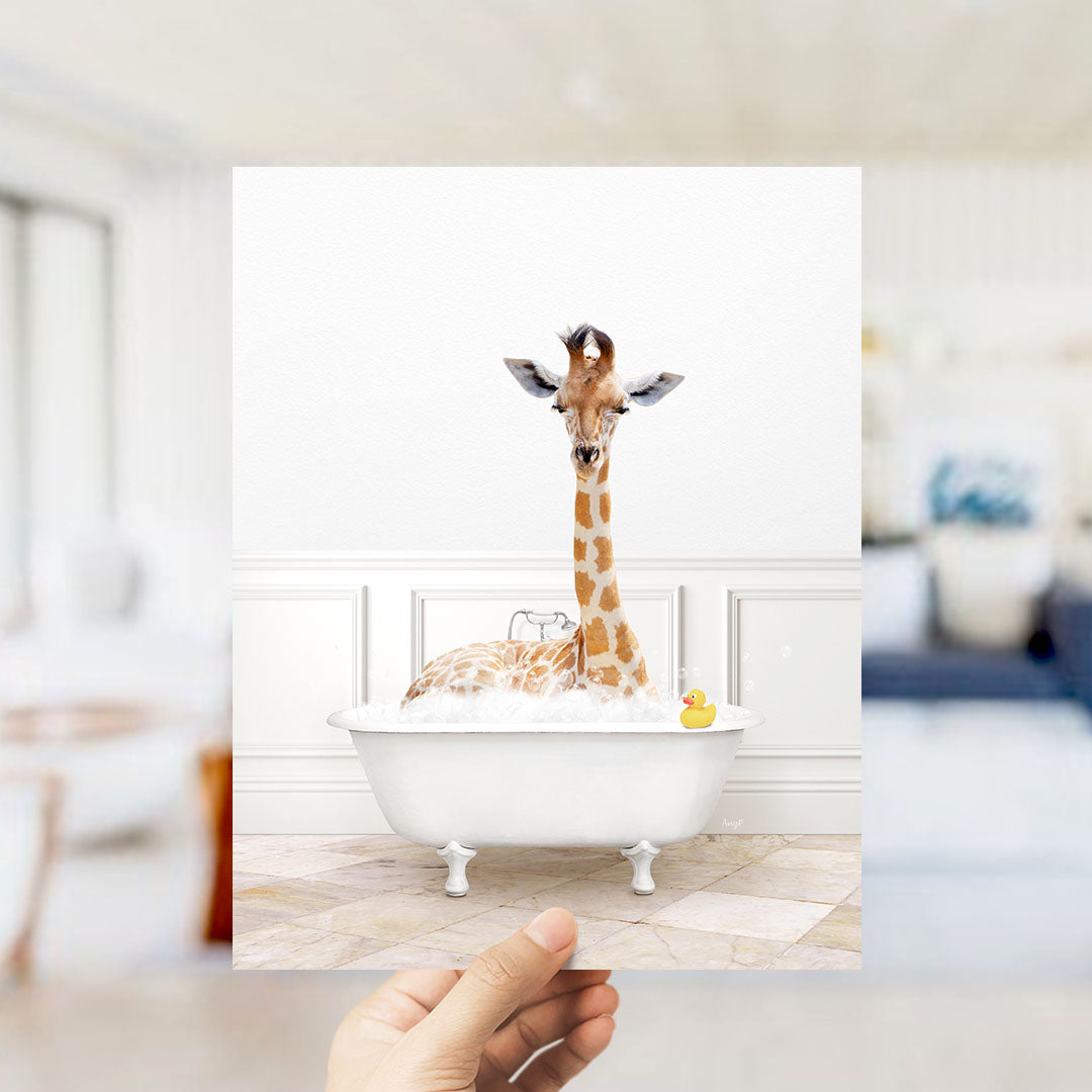 A giraffe sitting in a white bathtub filled with bubbles, with a yellow rubber duck floating on the water.