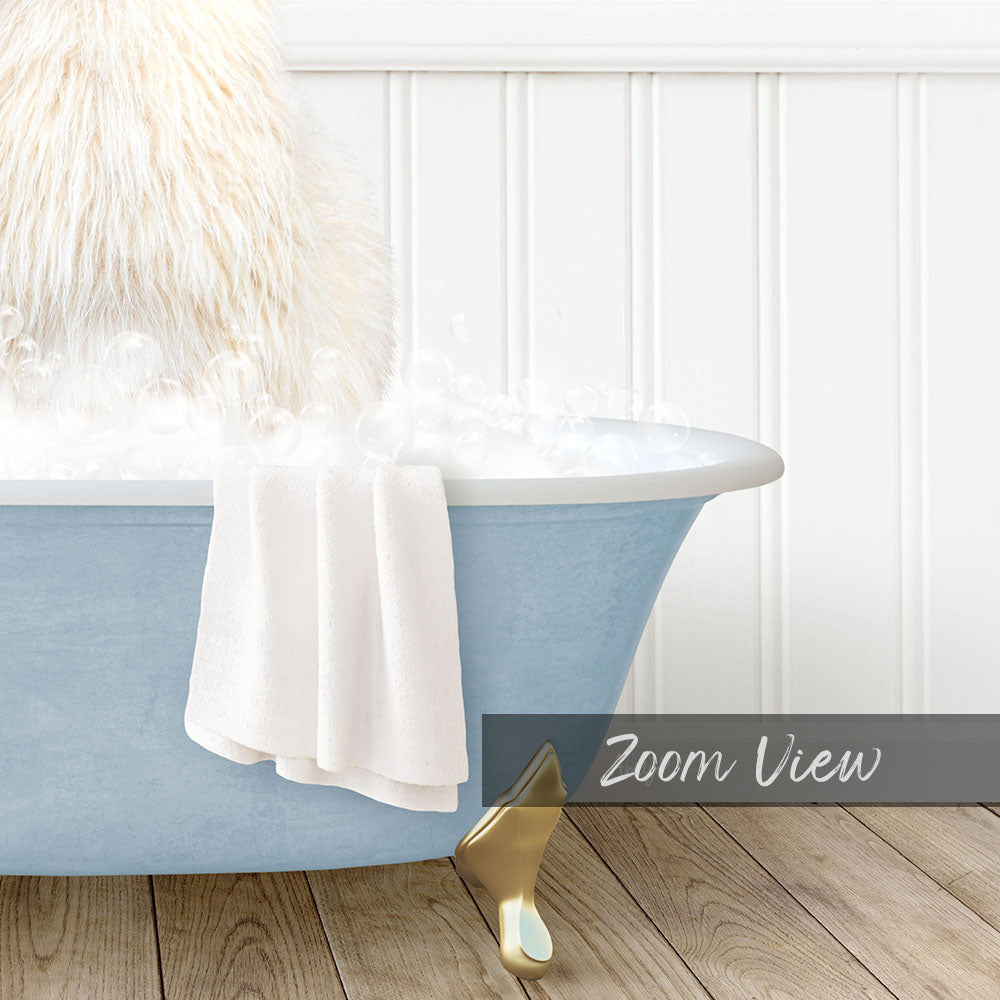 A fluffy white dog is sitting in a blue bathtub filled with bubbles, with a white towel hanging on the side and a "Zoom View" label below the image.