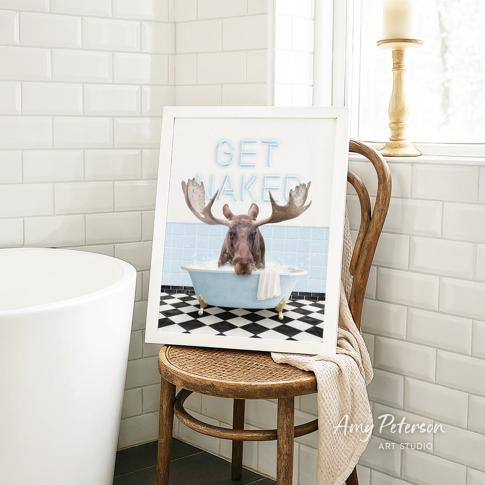 A framed image of a moose sitting in a bathtub, with the text "GET NAKED" displayed above it.