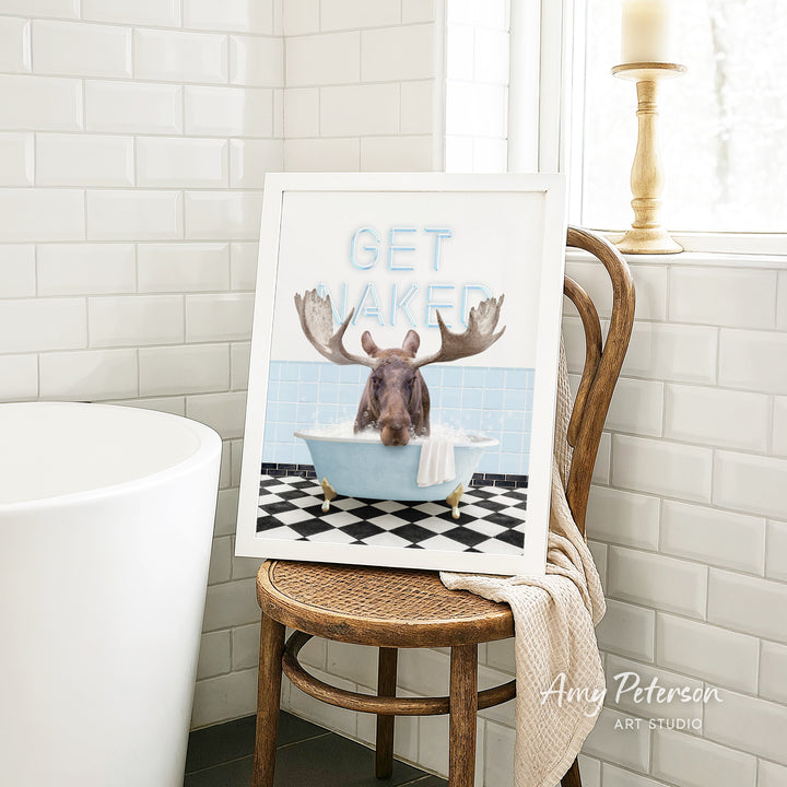A framed image of a moose sitting in a bathtub, with the text "GET NAKED" displayed above it.