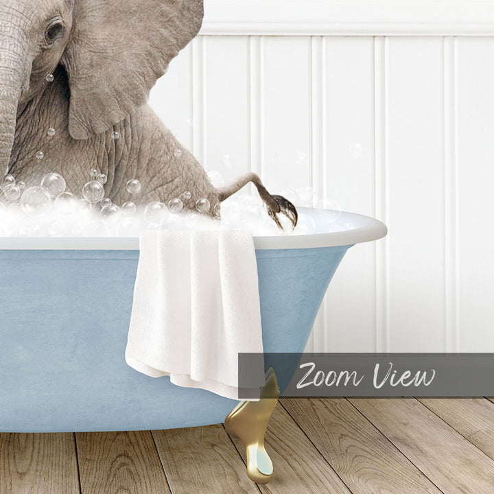 A large elephant is sitting in a blue bathtub filled with bubbles, with its trunk raised in the air.