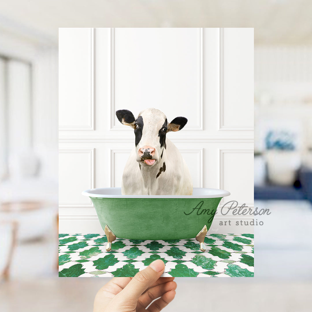 a hand holding a card with a picture of a cow in a bathtub