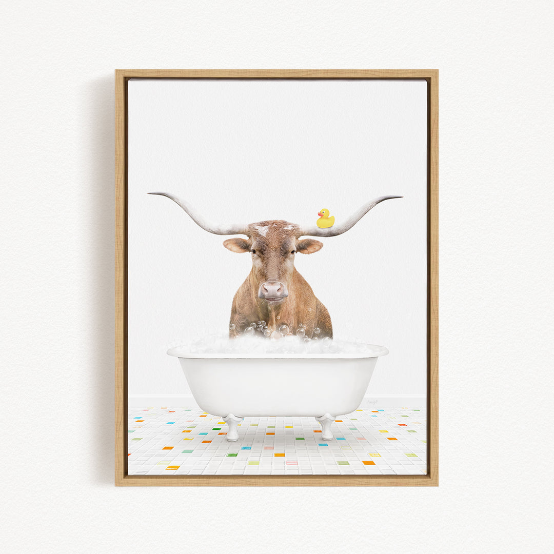 A brown cow with large horns is sitting in a white bathtub filled with bubbles, with a rubber duck floating on the water.