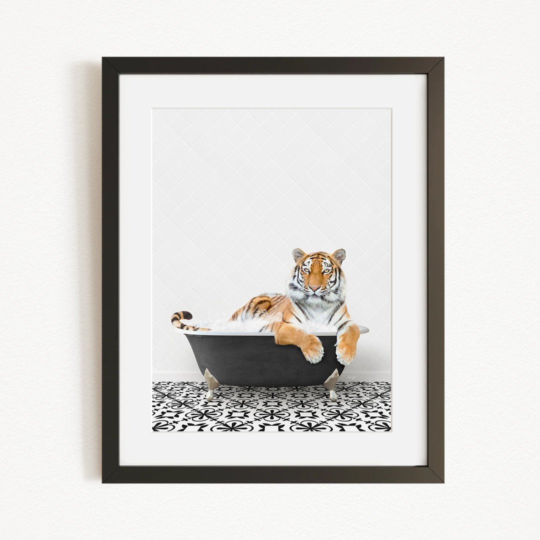 A tiger is sitting in a black bathtub, surrounded by a black and white patterned floor.