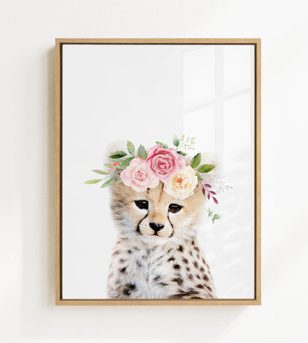A cheetah wearing a floral crown of pink and white flowers.