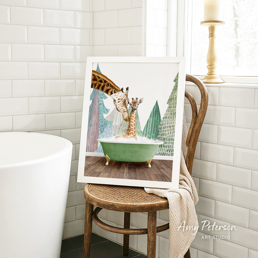 A framed image of two giraffes sitting in a green bathtub, surrounded by a snowy landscape, is displayed on a wooden chair in a bathroom setting.