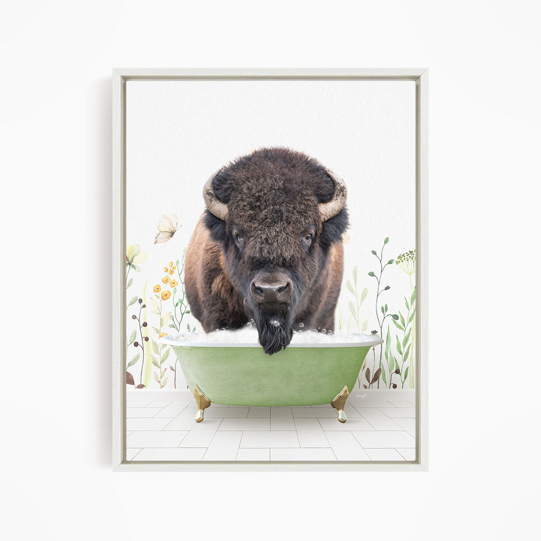 A buffalo with large horns is standing in a green bathtub, surrounded by flowers and plants.