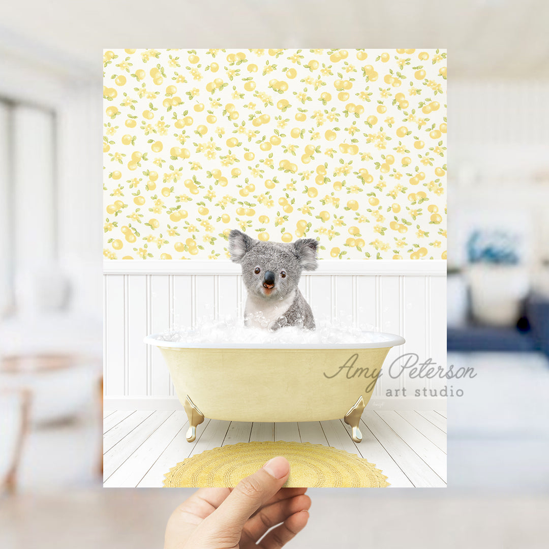 a hand holding up a picture of a koala in a bathtub