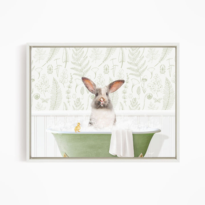 A white rabbit sitting in a green bathtub, surrounded by a white towel and a yellow rubber duck.