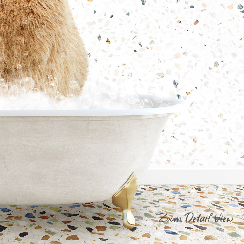 A fluffy brown cat is sitting in a white bathtub filled with bubbles, with a mosaic floor in the background.
