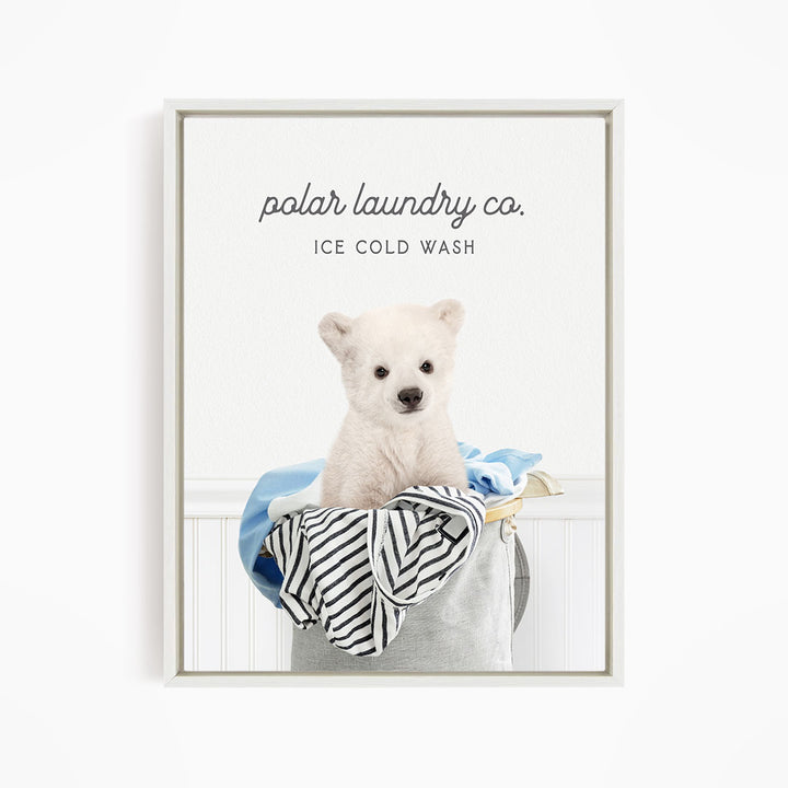A white polar bear sitting in a laundry basket filled with clothes, with the text "polar laundry co. ICE COLD WASH" displayed above the image.