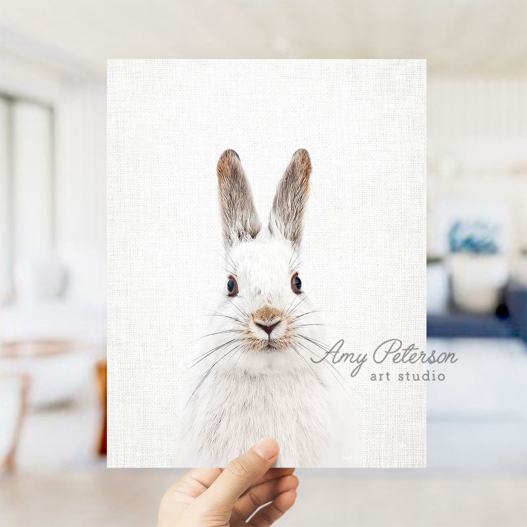 a person holding up a card with a picture of a rabbit