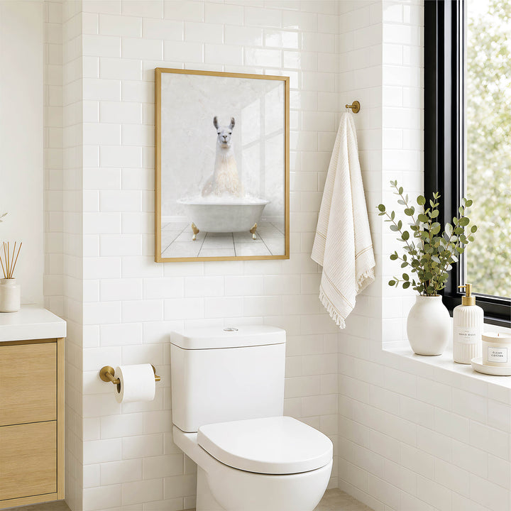 A bathroom with a white toilet, a framed picture of a llama in a bathtub, and a window with greenery on the sill.
