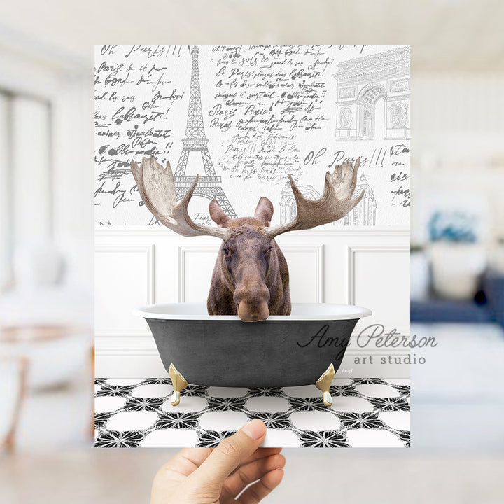 a person holding up a card with a moose in a bathtub