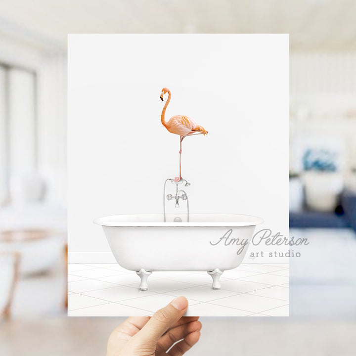 a person holding up a card with a flamingo in a bathtub