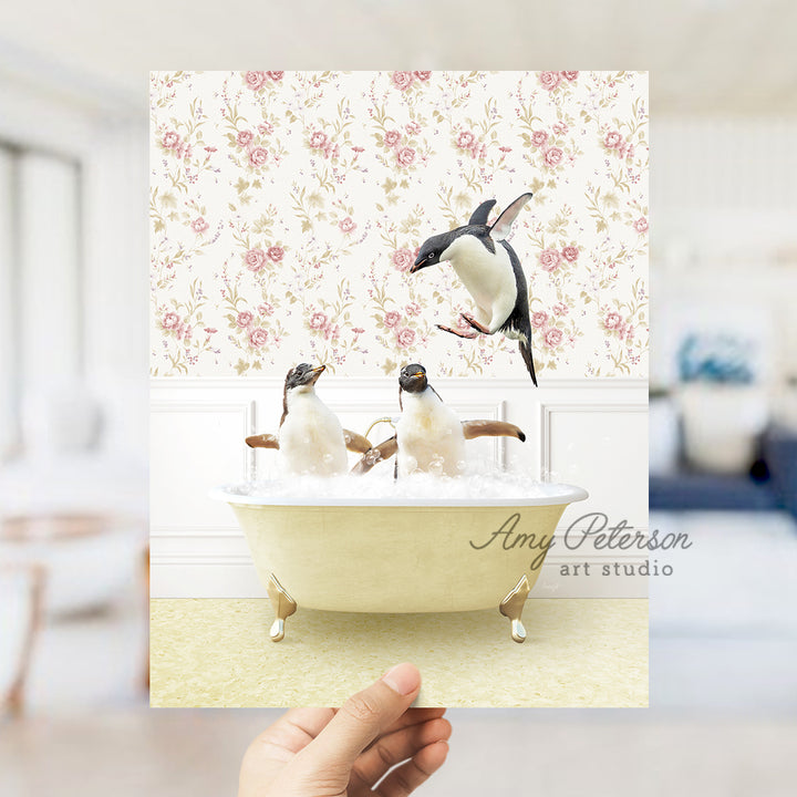 a hand holding up a card with penguins in a bathtub