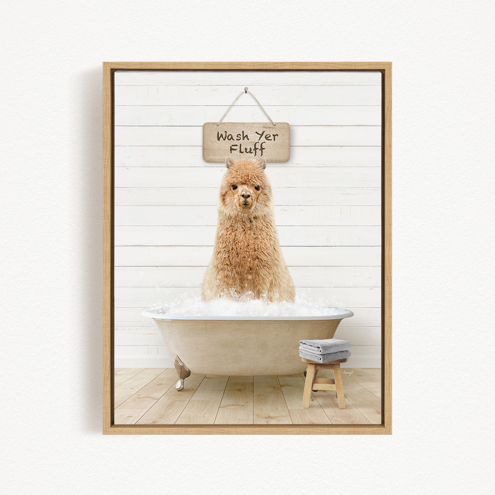 A brown alpaca sitting in a bathtub filled with water, with a wooden sign above it that says "Wash Yer Fluff".