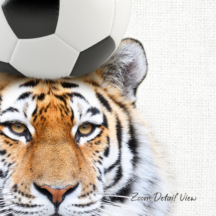 A close-up of a tiger's face with a soccer ball on top of it, against a white background.