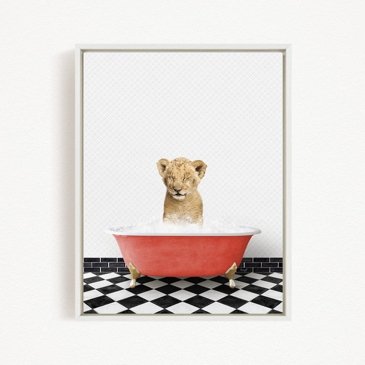 A young lion cub sitting in a red bathtub filled with water, surrounded by a black and white checkered floor.