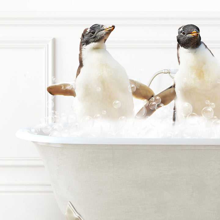 two penguins sitting in a bathtub full of bubbles