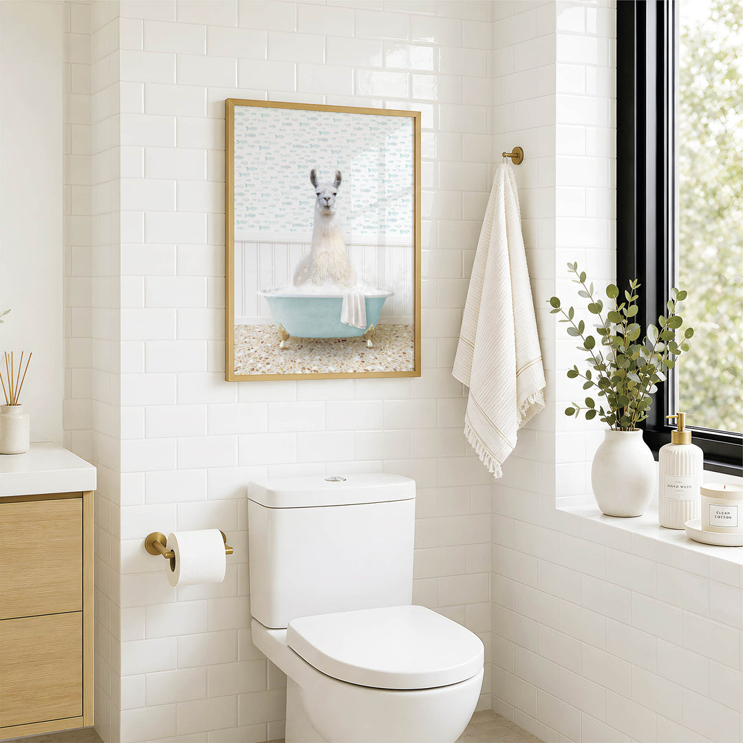 A bathroom with a white toilet, a framed picture of a llama in a bathtub, and a window with greenery on the sill.