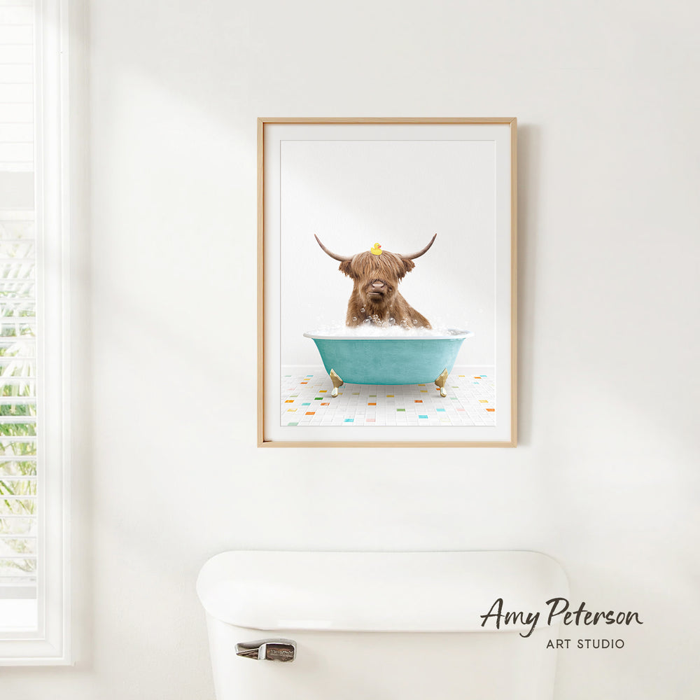 A framed image of a Highland cow sitting in a blue bathtub, with a yellow rubber duck floating on the water.