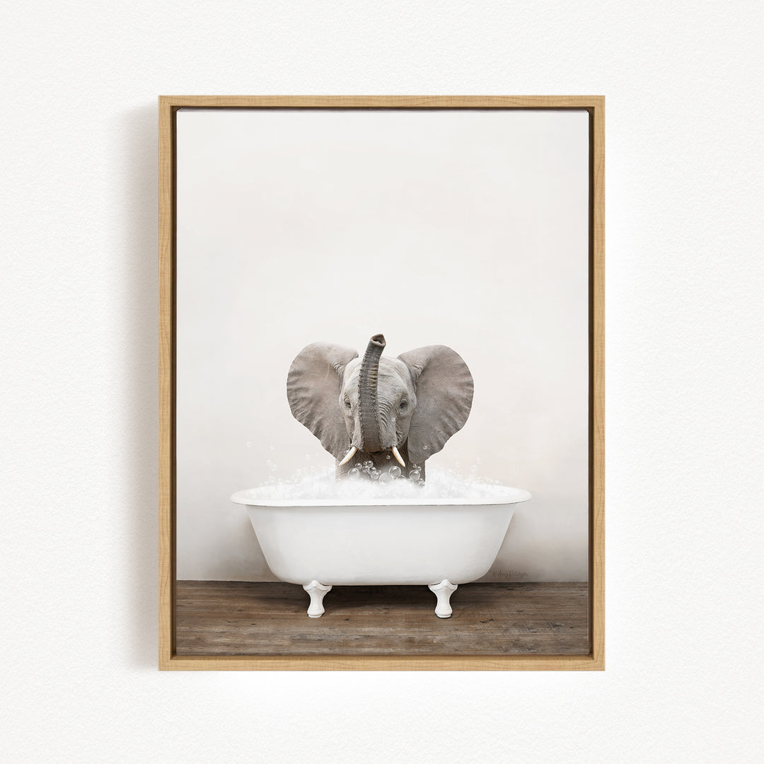 A baby elephant sitting in a white bathtub filled with water, with its trunk raised in the air.
