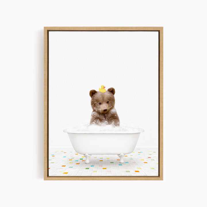 A cute brown bear sitting in a white bathtub filled with bubbles, wearing a yellow rubber duck hat.