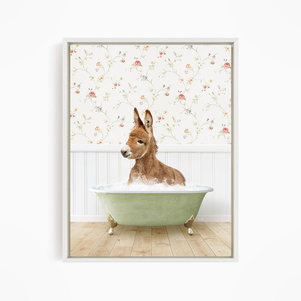 A donkey is sitting in a green bathtub filled with water, surrounded by a floral wallpaper.