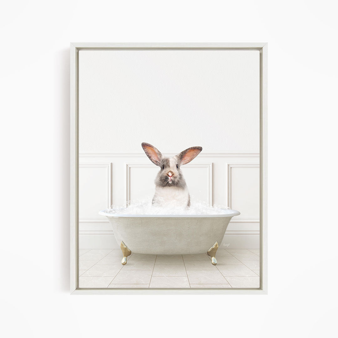 A white rabbit sitting in a white bathtub filled with water, looking directly at the camera.