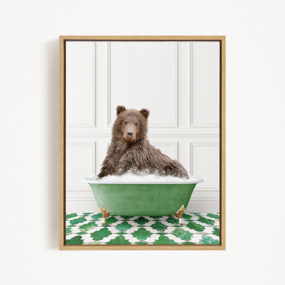 A brown bear sitting in a green bathtub filled with bubbles, with a patterned green and white rug on the floor.