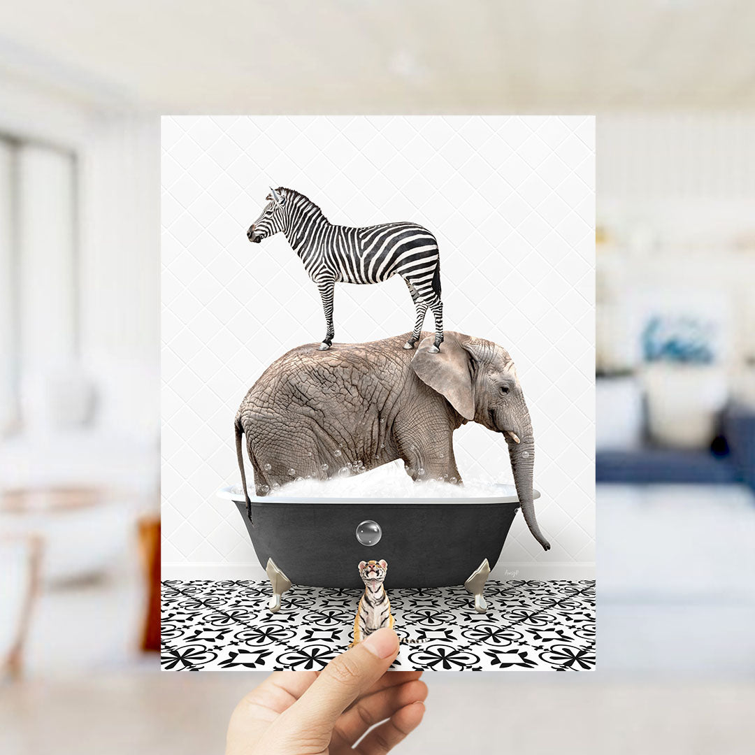 A hand holds up a collage of two images: a zebra standing on an elephant's back in a bathtub, and a small animal, likely a meerkat, standing in front of the elephant.
