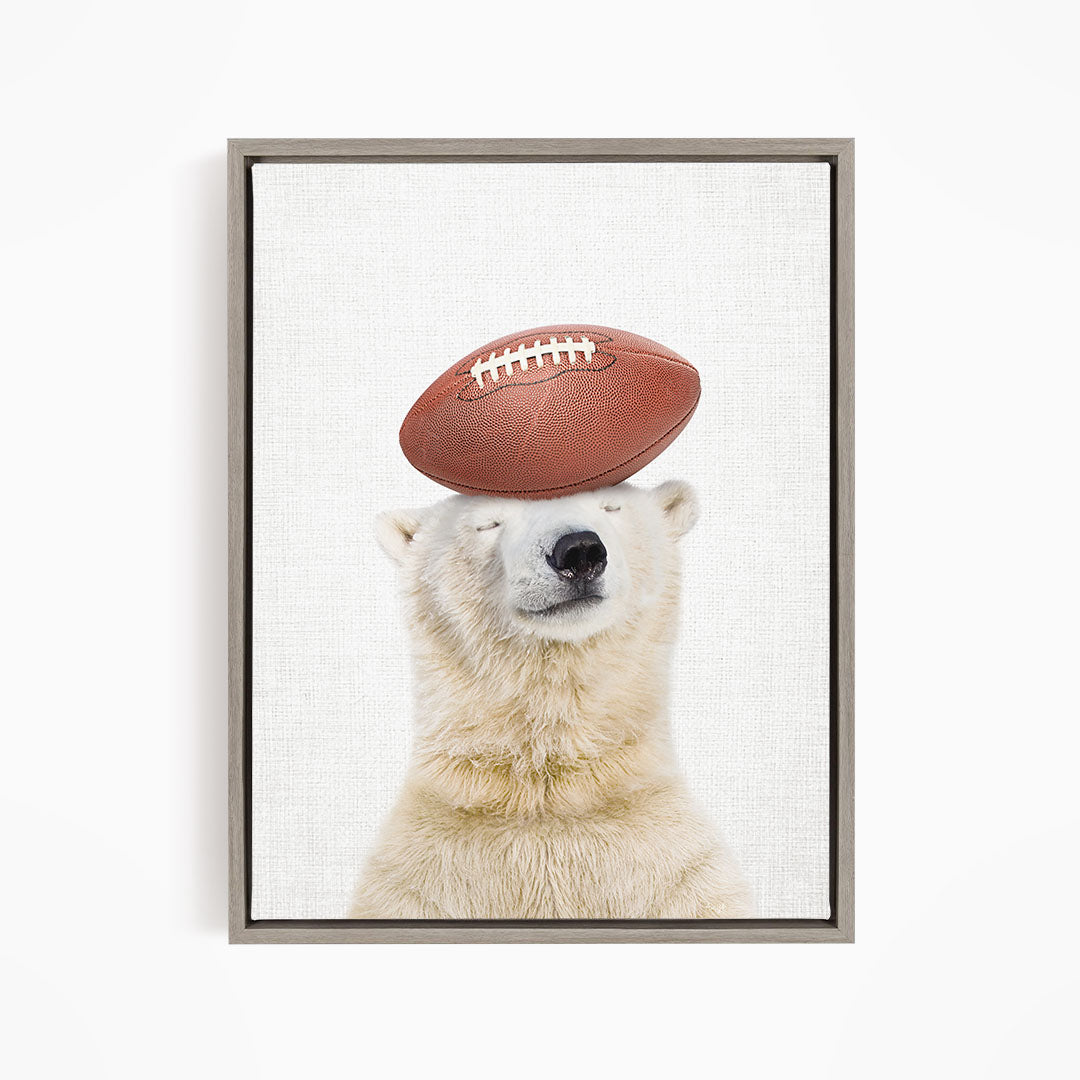 A polar bear balancing a football on its head.
