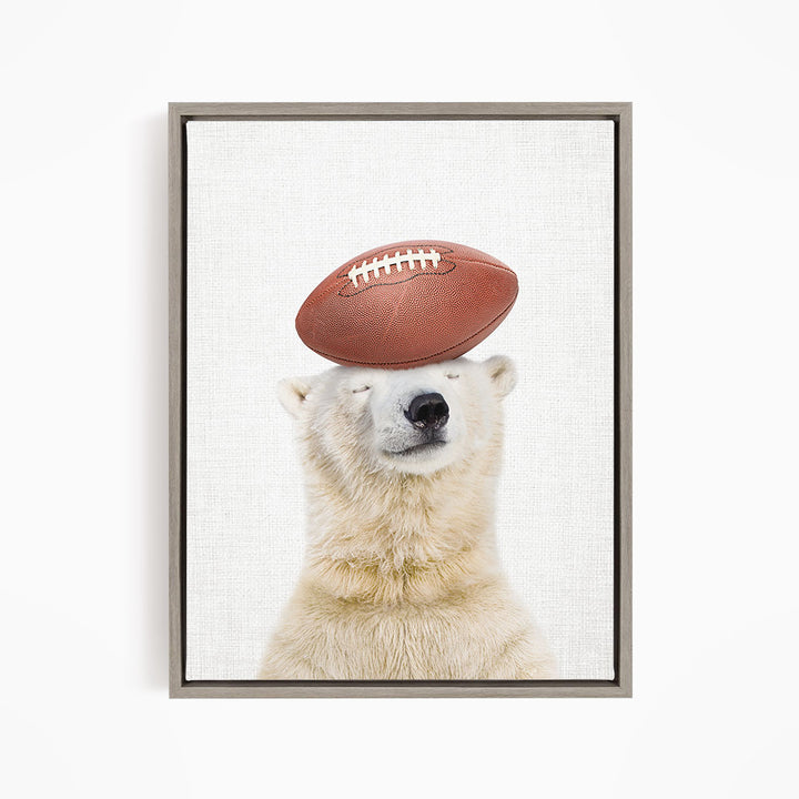A polar bear balancing a football on its head.