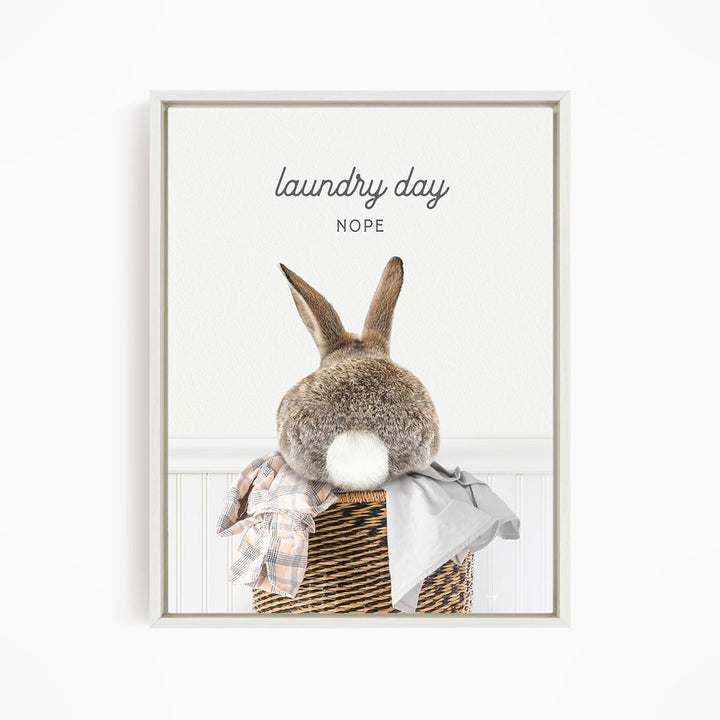 A rabbit sitting in a laundry basket, with the text "laundry day NOPE" above it.