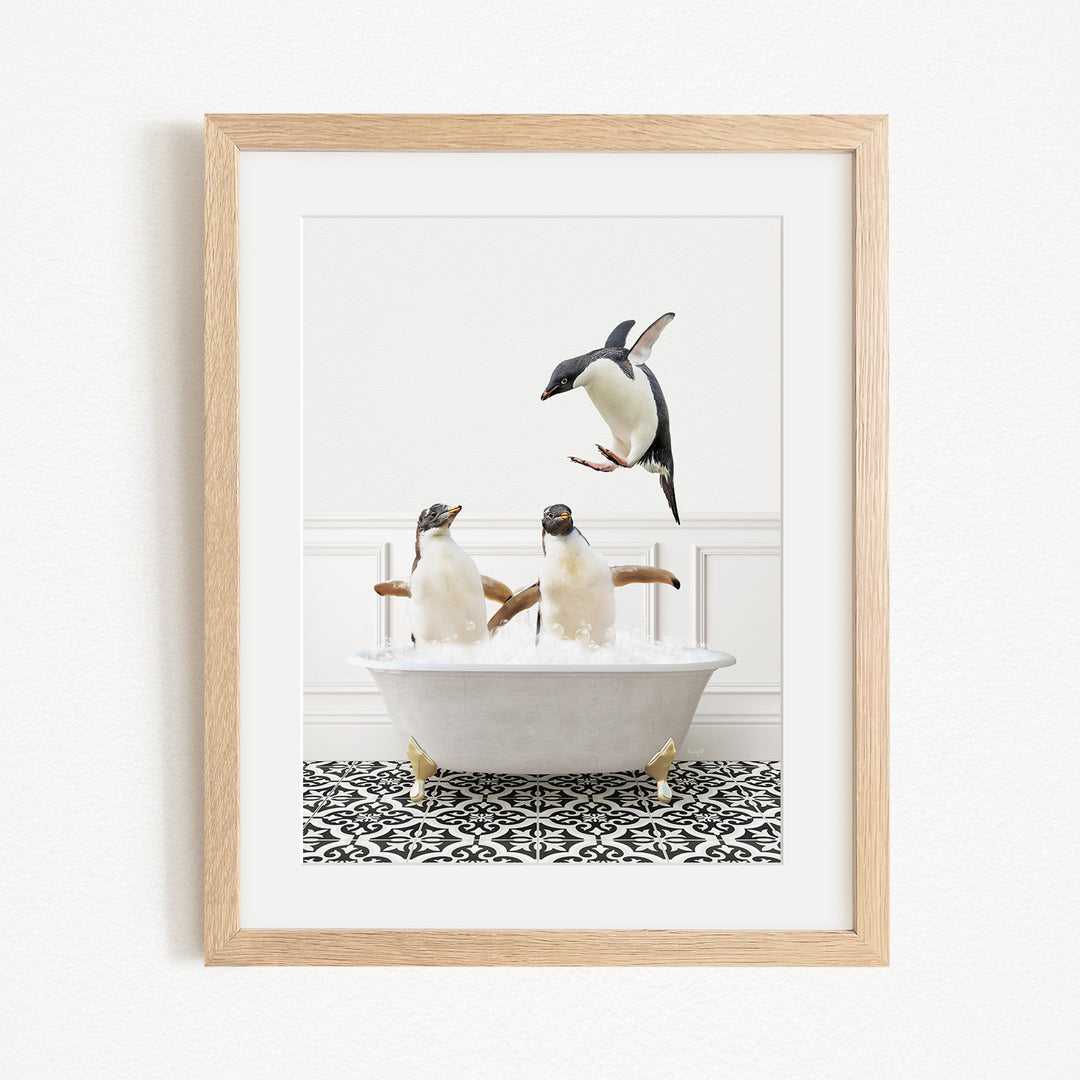A framed image depicting two penguins sitting in a bathtub, with one penguin flying towards the other.