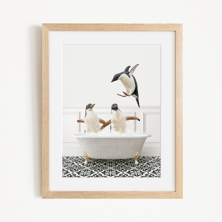 A framed image depicting two penguins sitting in a bathtub, with one penguin flying towards the other.