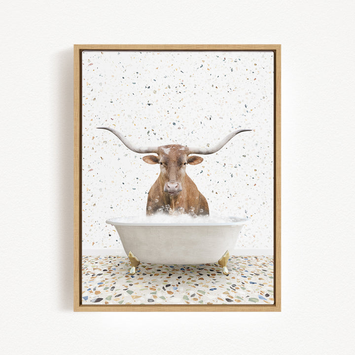 A brown cow with large horns is sitting in a white bathtub filled with water, surrounded by a speckled floor.